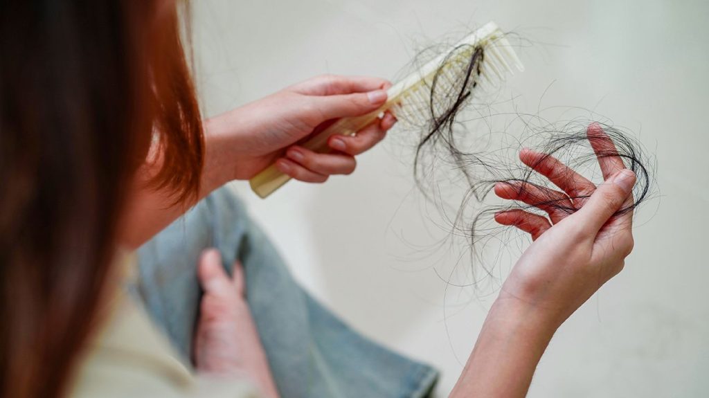 Female pulls hair out of brush