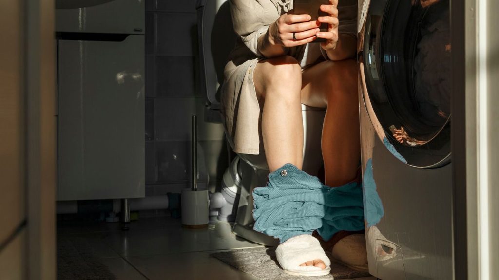 Person on toilet scrolling on phone