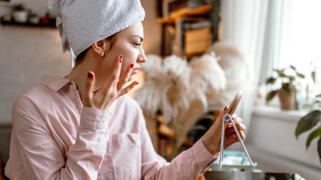 Young female applying baking soda to face