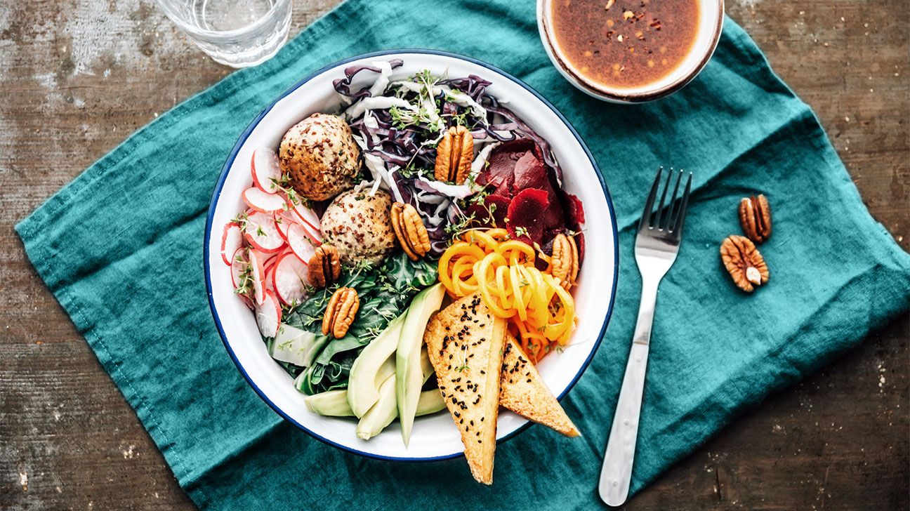 A bowl full of healthy foods on top of a teal cloth napkin