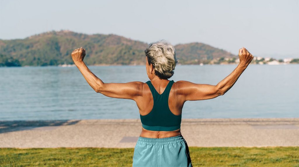 Older woman exercises outdoors by a lake
