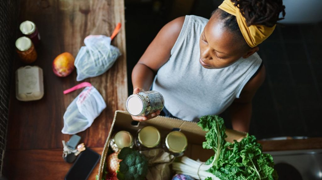 Overhead view of female unpacking healthy groceries