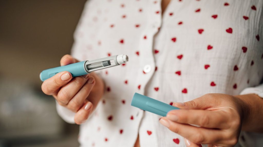 Person holding a GLP-1 pen